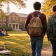Two students with backpacks walking across a boarding school campus lawn toward a brick academic building, symbolizing authenticity and everyday student life.