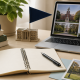 Cozy study desk with notebook, laptop displaying campus images, books, and stationery in a warm academic setting.