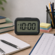 Digital clock showing 10:00 AM on a tidy study desk with books, notebook, and test sheet