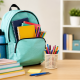 Back-to-school setup with backpack, notebooks, and colorful supplies on a desk.