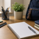 Neatly arranged study desk by a window with an open notebook, pen, stacked books, a small plant, and a backpack in soft natural light
